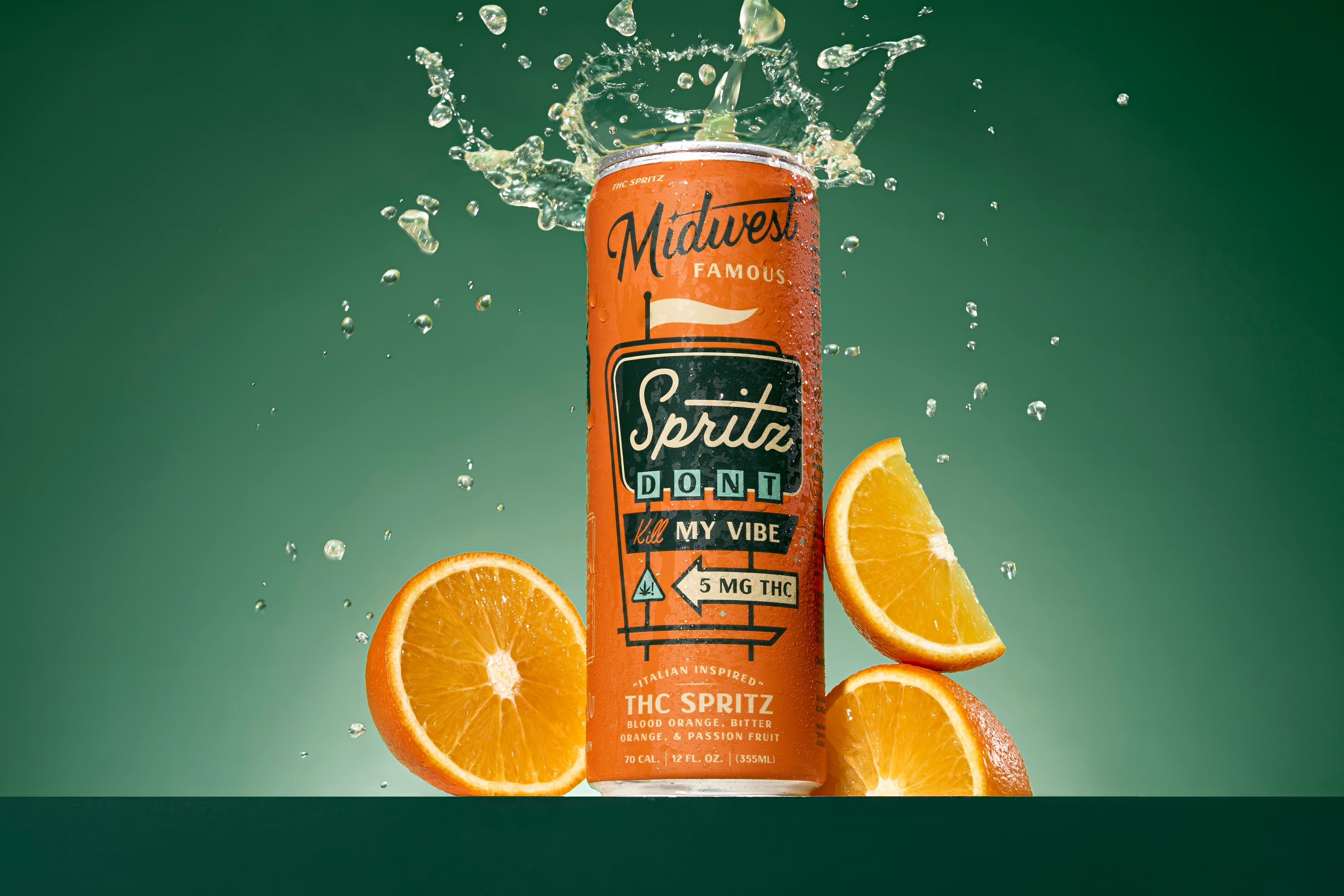 An orange can spewing liquid with a green background and oranges in the foreground