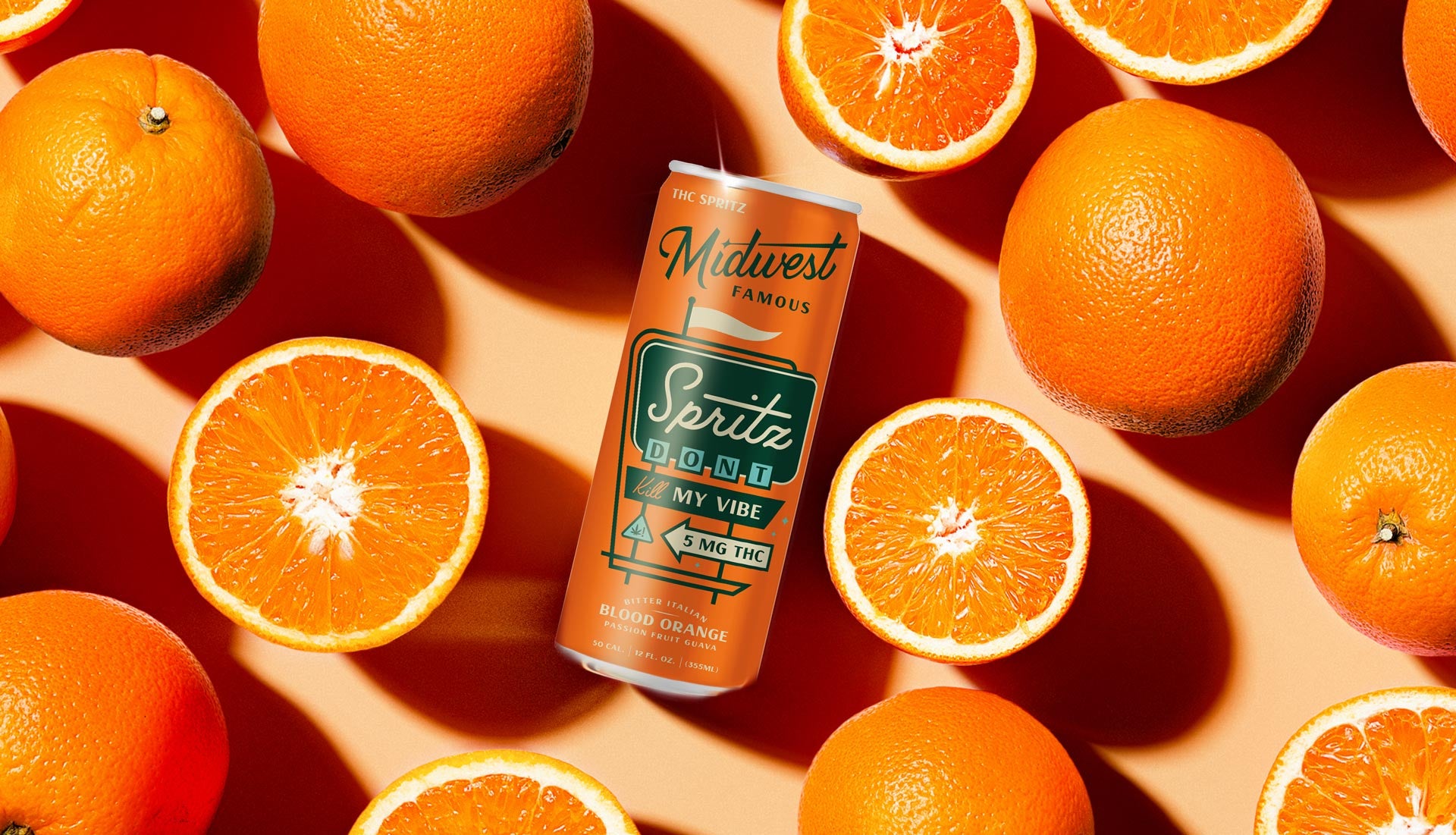 a can of blood orange thc spritz laying in front of an orange background surrounded by cut up blood oranges
