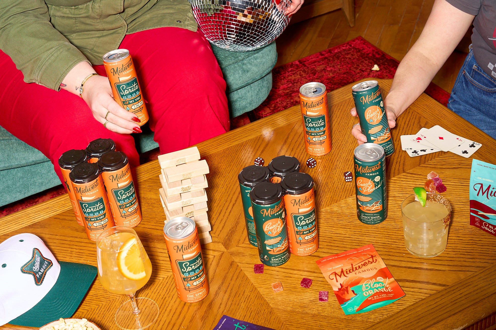 a table with multiple four packs of thc cocktails, cards, and gummies