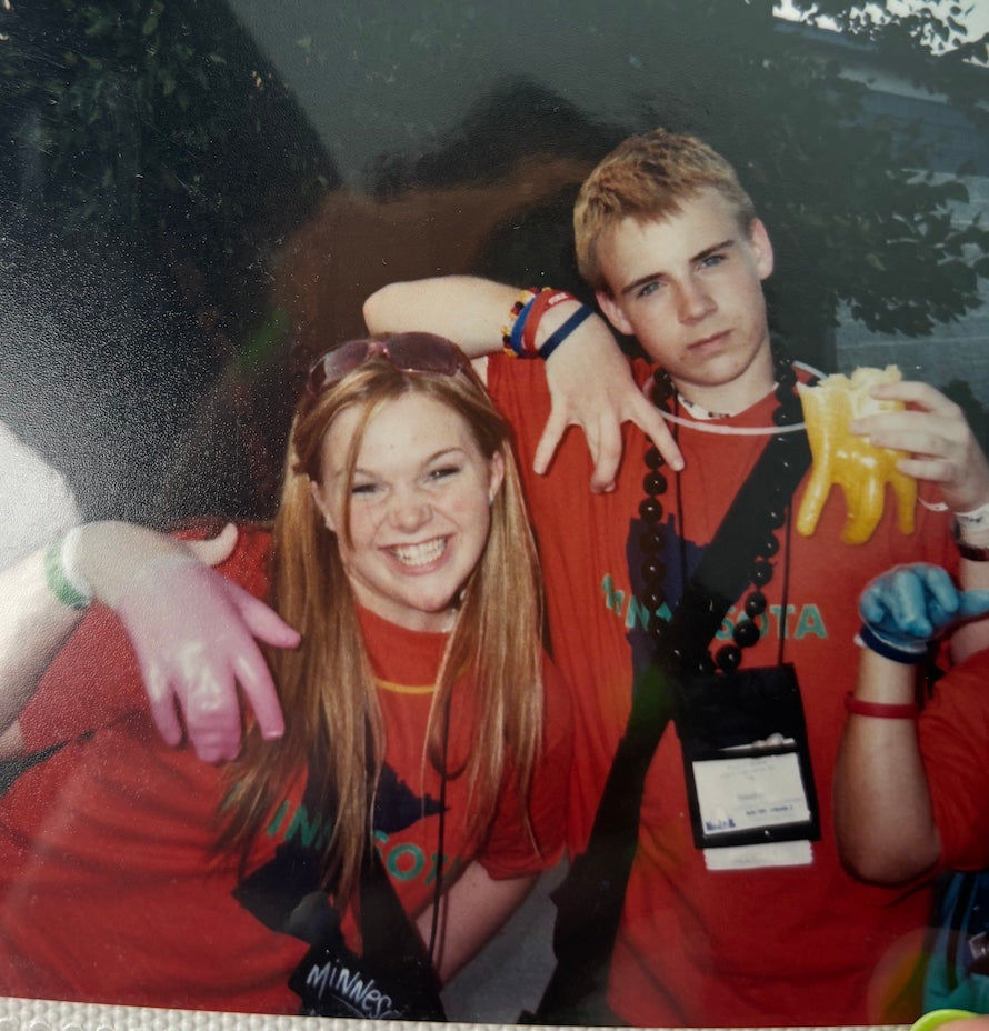 two kids in red shirts holding up their right hands
