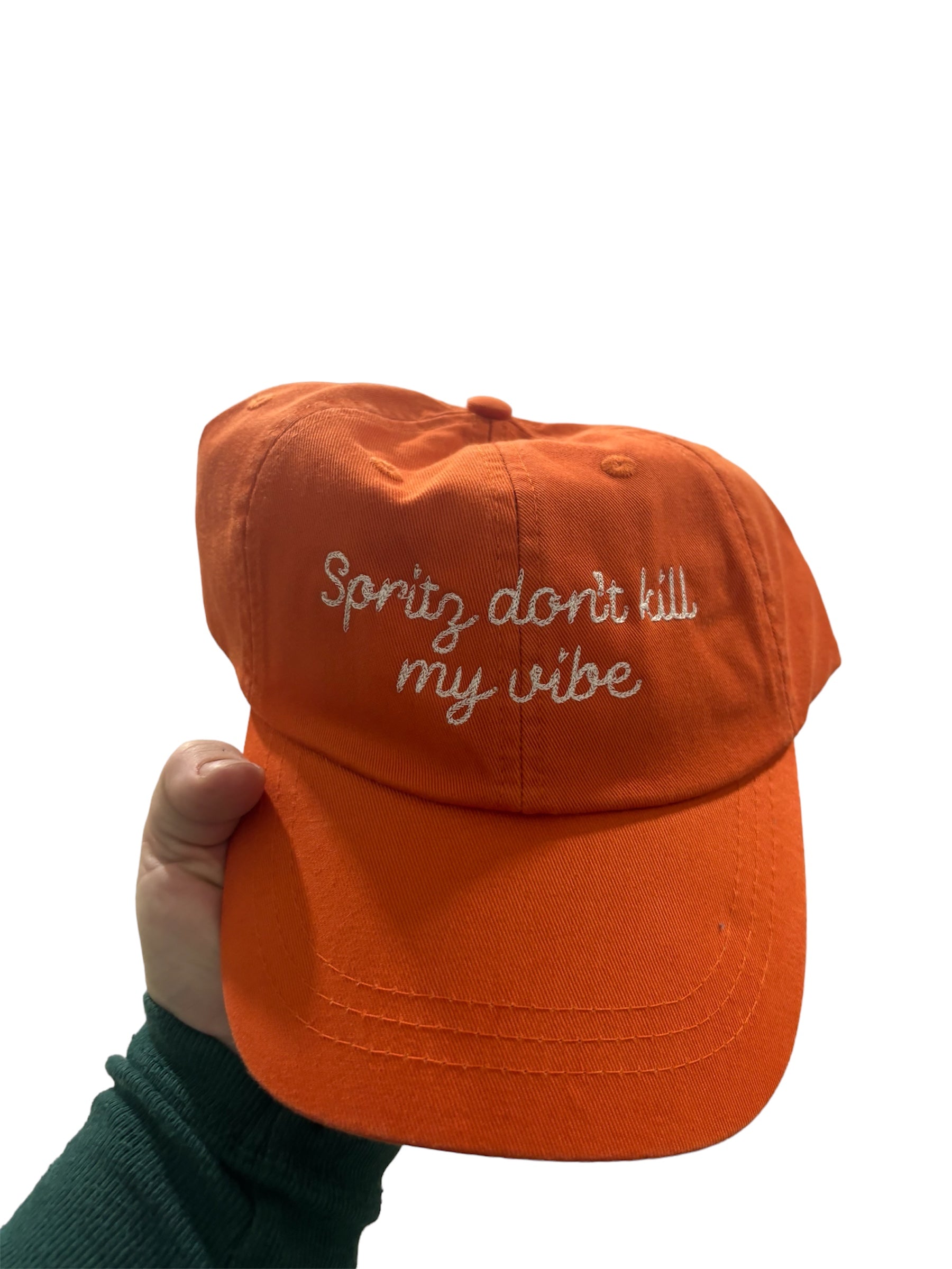 an orange baseball cap with white text on the front